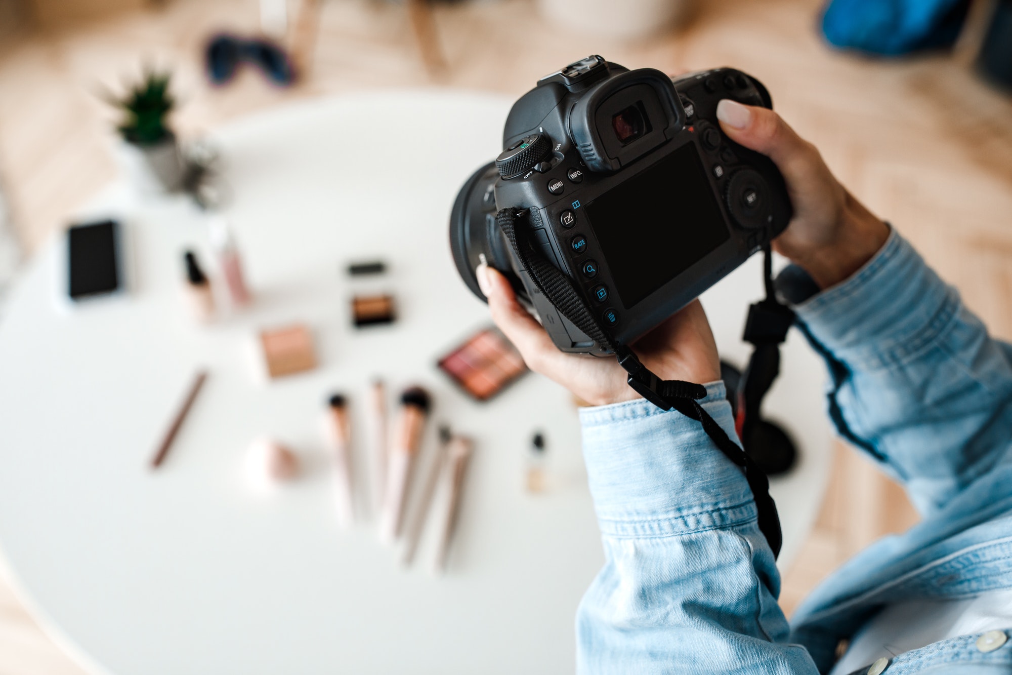 Unrecognizable Female Photographer Taking Photo Of Cosmetic Products Indoor, Cropped